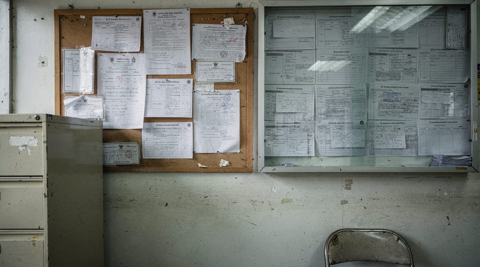 A Thai government labour-office noticeboard of printed occupation notices and laminated cards.
